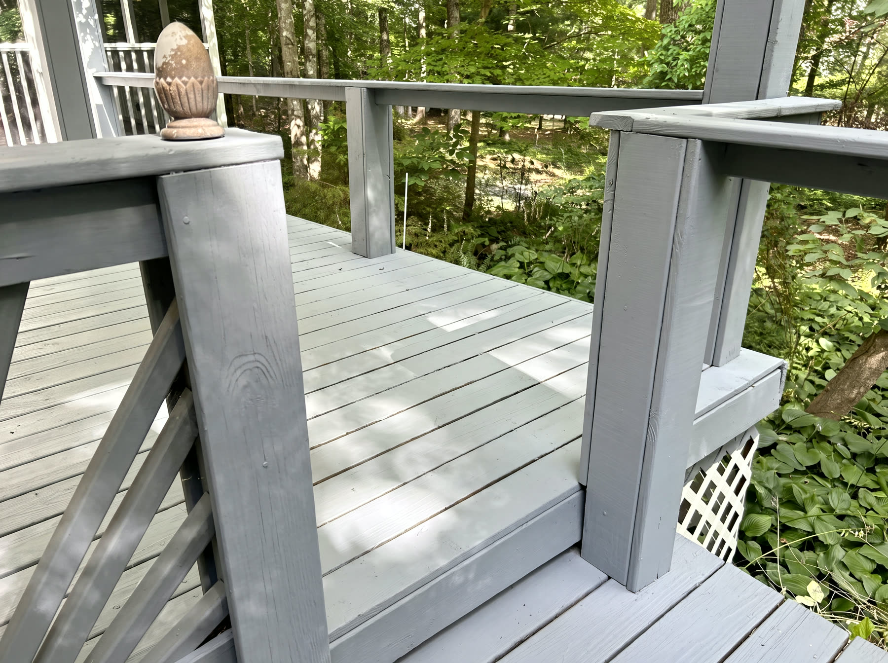 Restored porch with custom white sunburst railing panels and turned columns