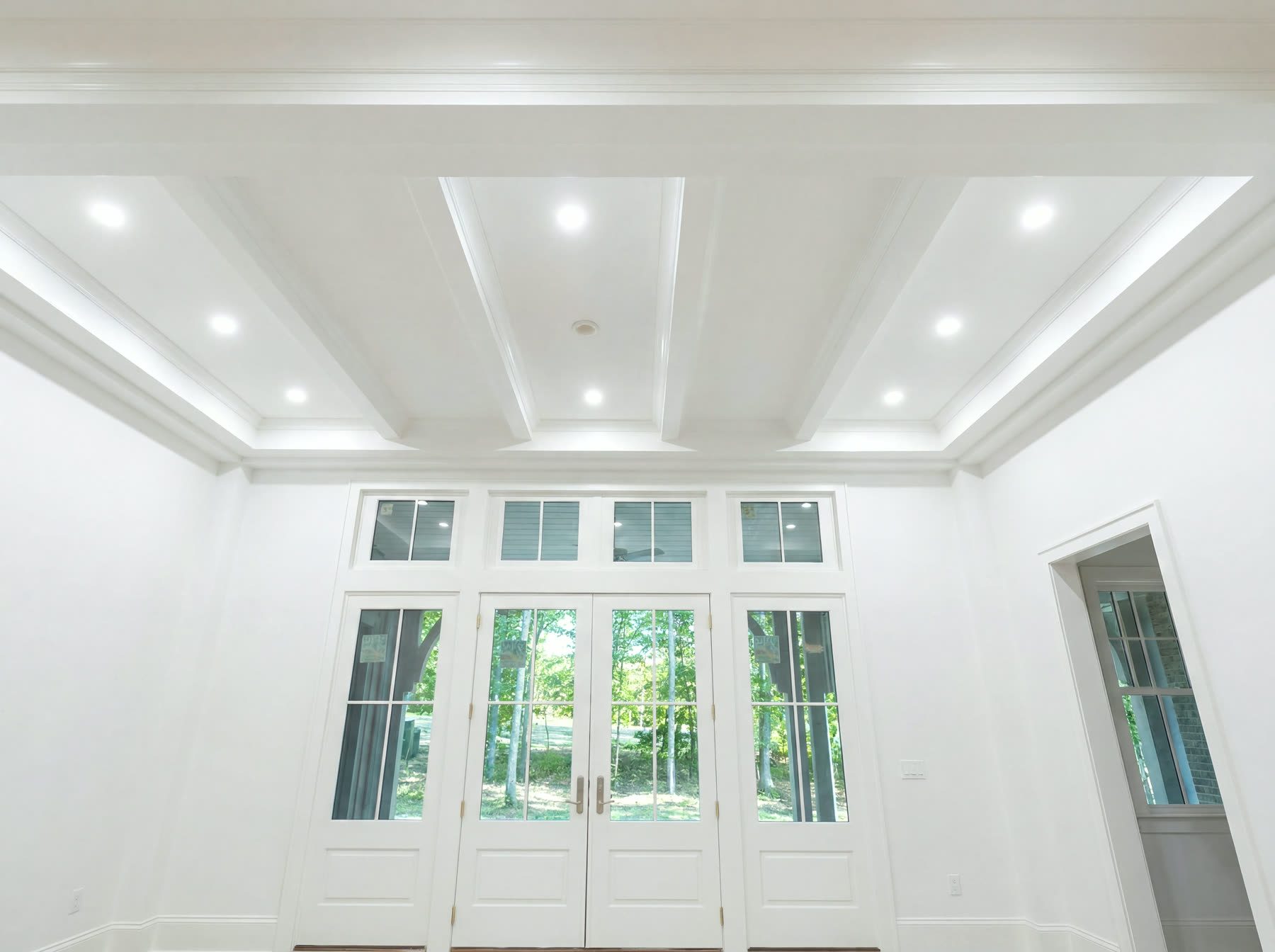 White coffered ceiling with recessed lighting, custom finish carpentry in a Plateau home
