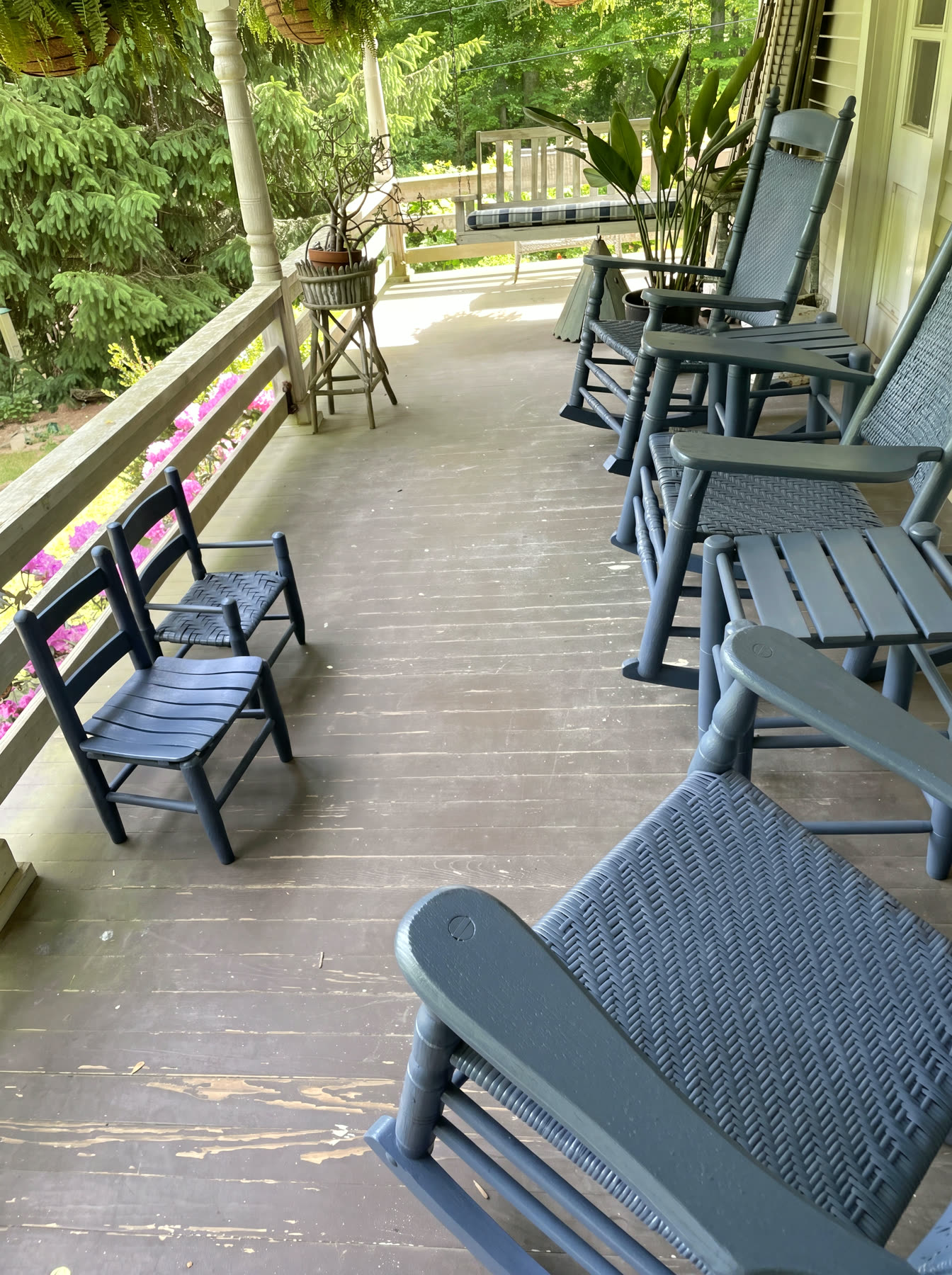Rebuilt covered cottage front porch with turned columns and blue woven-seat rockers
