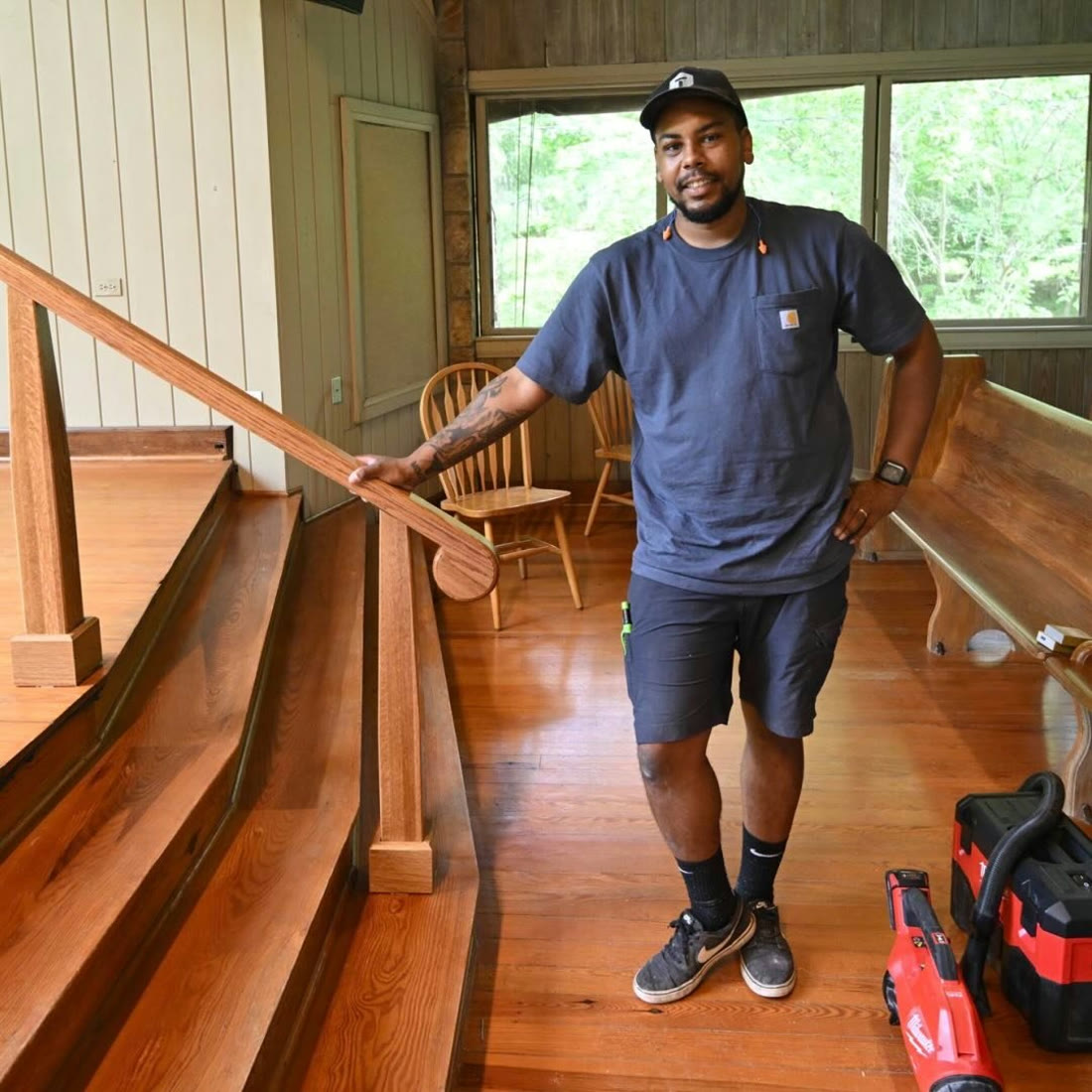 Ricky Scripter standing at the custom white-oak handrails he built in a Cumberland Plateau forest chapel