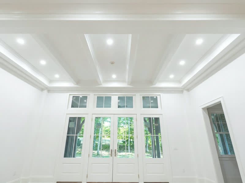 White coffered ceiling with recessed lighting, custom finish carpentry in a Plateau home